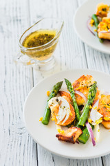 Salad with fried halloumi, asparagus and orange zest. White wooden background