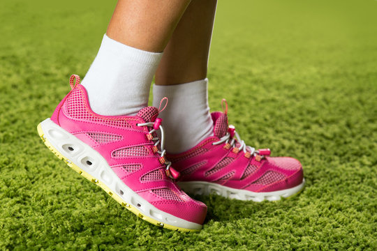 Pink sneakers on the legs of a woman