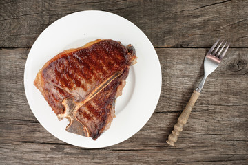 Gegrilltes T-Bone Steak auf Teller mit Gabel
