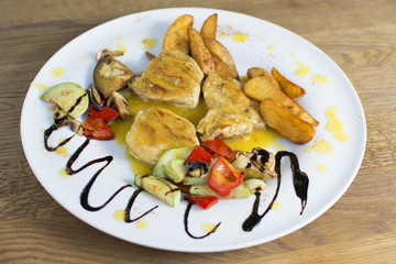 Grilled chicken breast with vegetables and sauce on a plate. Traditional cuisine. Grill kitchen.