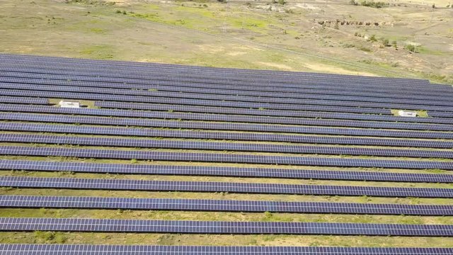 Aerial View. Flying over the solar power plant with sun. Solar panels and sun. Aerial drone shot. 4K 30fps ProRes (HQ).