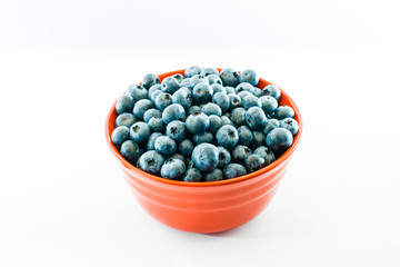 Red bowl full of fresh juicy blueberries