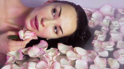 Obraz na płótnie Canvas Woman with Fresh Rose petals and pink rosebud. Natural Rose water