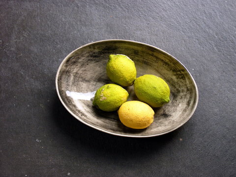 Runde Obstschale mit gelben Zitronen auf grauem Bertonboden als Stillleben in einer Designerwohnung in einem Landhaus in Rudersau bei Rottenbuch im Kreis Weilheim-Schongau in Oberbayern