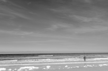 Fisherman walking into the sea, black white
