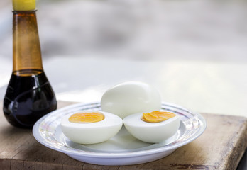 Boiled eggs in a dish placed on the chopping board.