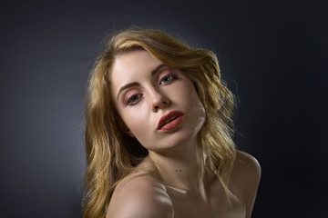 Fototapeta premium Attractive blonde woman on dark background .