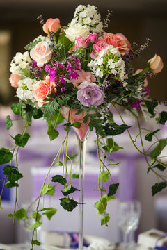 Vase and floral composition on the wedding served table in a restaurant