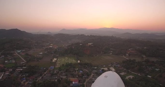 Sunset Behind Mountains and Goddess of Mercy Statue, Chiang Rai, Thailand, Descending Shot
