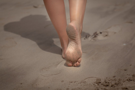 woman feet, walking on the beach