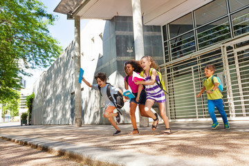 Group of kids run from the school