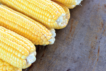 Fresh corn on wooden table, closeup, top view