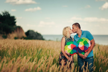 Kissing couple in high grass with toy windmill