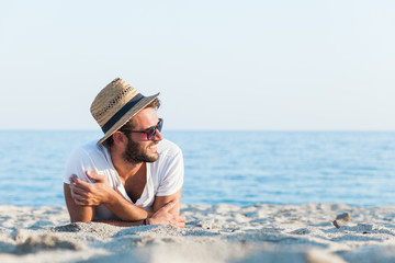 Young hipster man lying on the beach