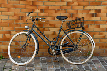 Fototapeta na wymiar bicycle on cobblestone street leaning on brick wall