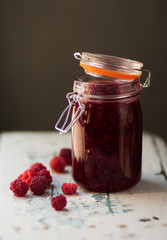 Homemade jam with raspberry on the wooden table.