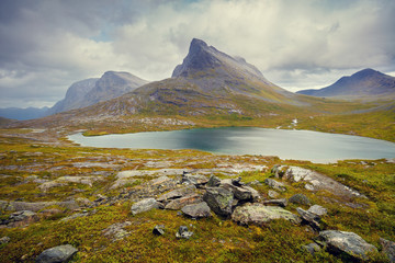 Mountain landscape. Rocky shore of mountain lake in rainy autumn morning. Beautiful nature Norway.