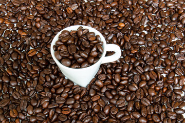 Espresso cup filled and surrounded by coffee beans