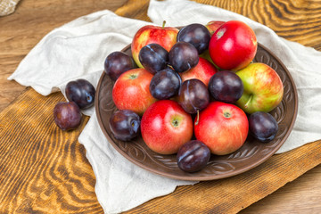 fruits, apples and plums on a plate