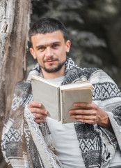 The young man at the tree reading a book