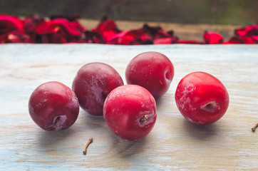 Red ripe plums on a wooden background closeup