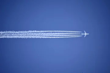 Fotobehang Een straalvliegtuig dat een condensatiespoor achterlaat © Mark