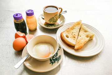 Asian traditional breakfast half boiled eggs, toast bread and coffee