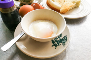 Asian traditional breakfast half boiled eggs, toast bread and coffee