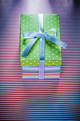 Cardboard box with present on red striped fabric celebrations co