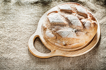 Chopping board bread on burlap background