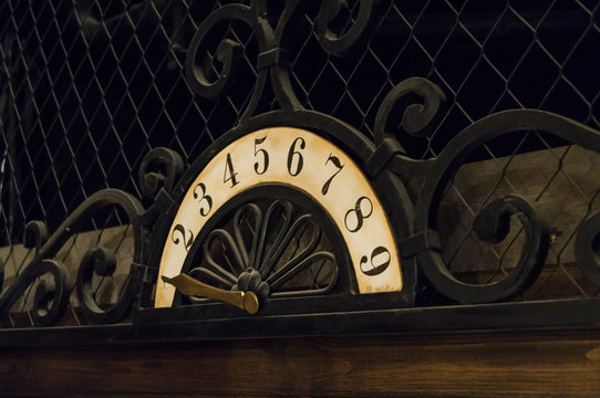 An ancient placard with figures and an iron pointer used in the elevator