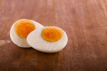 two halves of boiled eggs on wooden rustic background.