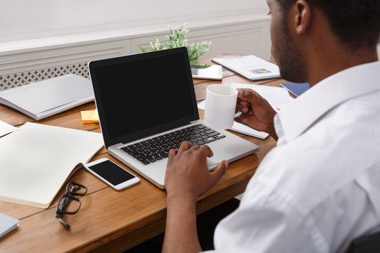 African-american businessman in office type on laptop