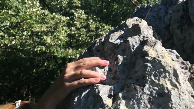 Young female climbs off the rock slow-mo  footage - Slow motion of woman descending the cliff  video 