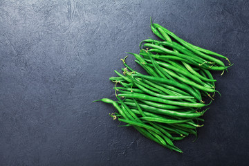 Young green or string beans on black stone table top view. Organic vegetarian food.