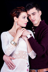 Romantic portrait of a young couple. Shot in the studio with a black background