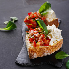Bruschetta with cheese and vegetables on black background