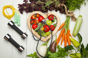 Fresh vegetables. Diet, a healthy lifestyle. Sport, dumbbells and a skipping rope on a white background - 167696691
