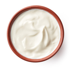 Cream in clay bowl isolated on white, from above