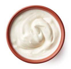 Cream in clay bowl isolated on white, from above