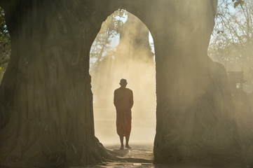 Buddhist monks are walking on temple in mist sunset,Thailand