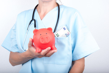 Arzt mit Sparschwein und Geld