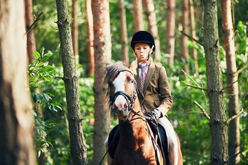 Girl riding a horse in forest