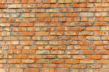 Fototapeta premium Background of old vintage dirty brick wall with peeling plaster, texture