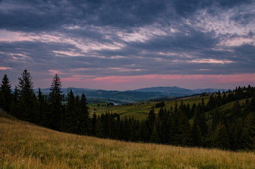 Naklejka na ściany i meble Background with Ukrainian Carpathian Mountains during the sunset in the Pylypets