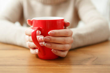 Female holding a cup of hot drink, close up
