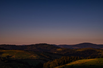 Fototapeta premium Background with Ukrainian Carpathian Mountains during the sunset in the Pylypets