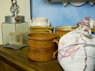 Old kitchen utensils, mugs, hand whipped cream, a bag of flour on the table.