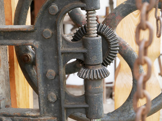 Vintage gears of the agricultural machine. Old machinery details closeup. Rusty gear wheels.