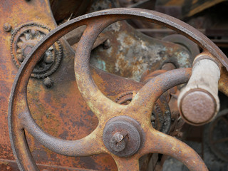 Vintage grain grinder machine. Old machinery details closeup. Rusty gear wheels.